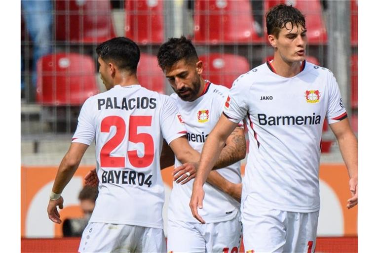 Leverkusens Kerem Demirbay (2. v. l.), Exequiel Palacios (l) und Patrik Schick freuen sich über den zweiten Saisonsieg. Foto: Matthias Balk/dpa
