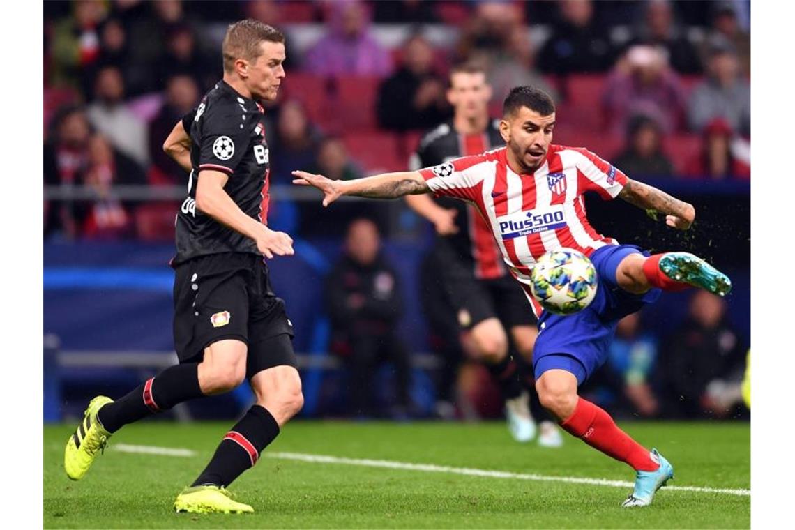 Leverkusens Lars Bender (l) nimmt Anlauf auf Atléticos Angel Correa. Foto: Marius Becker/dpa