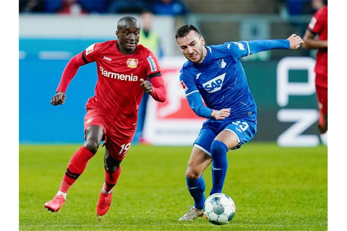 Leverkusens Moussa Diaby (l) und Hoffenheims Sargis Adamyan kämpfen um den Ball. Foto: Uwe Anspach/dpa/Archivbild