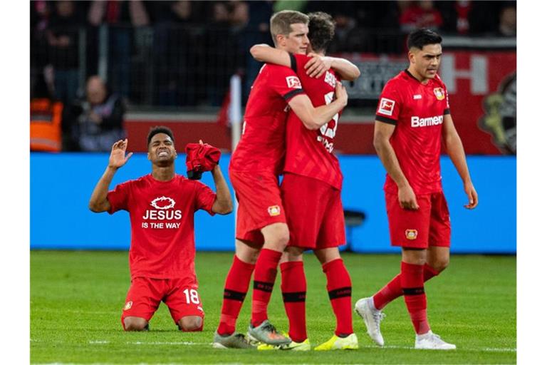 Leverkusens Spieler zeigen sich nach dem Spiel gegen Schalke über den Sieg erleichtert. Foto: Guido Kirchner/dpa