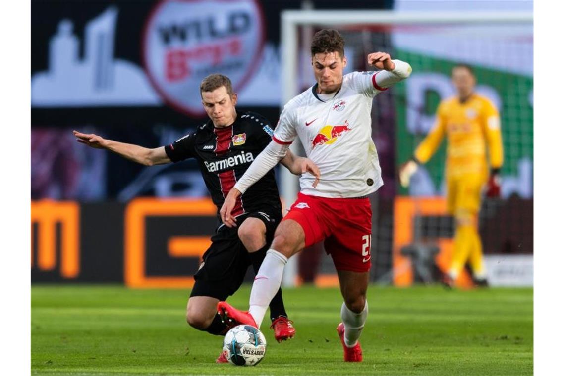 Leverkusens Sven Bender (l) geht gegen Leipzigs Patrik Schick von hinten in den Zweikampf. Foto: Robert Michael/dpa-Zentralbild/dpa