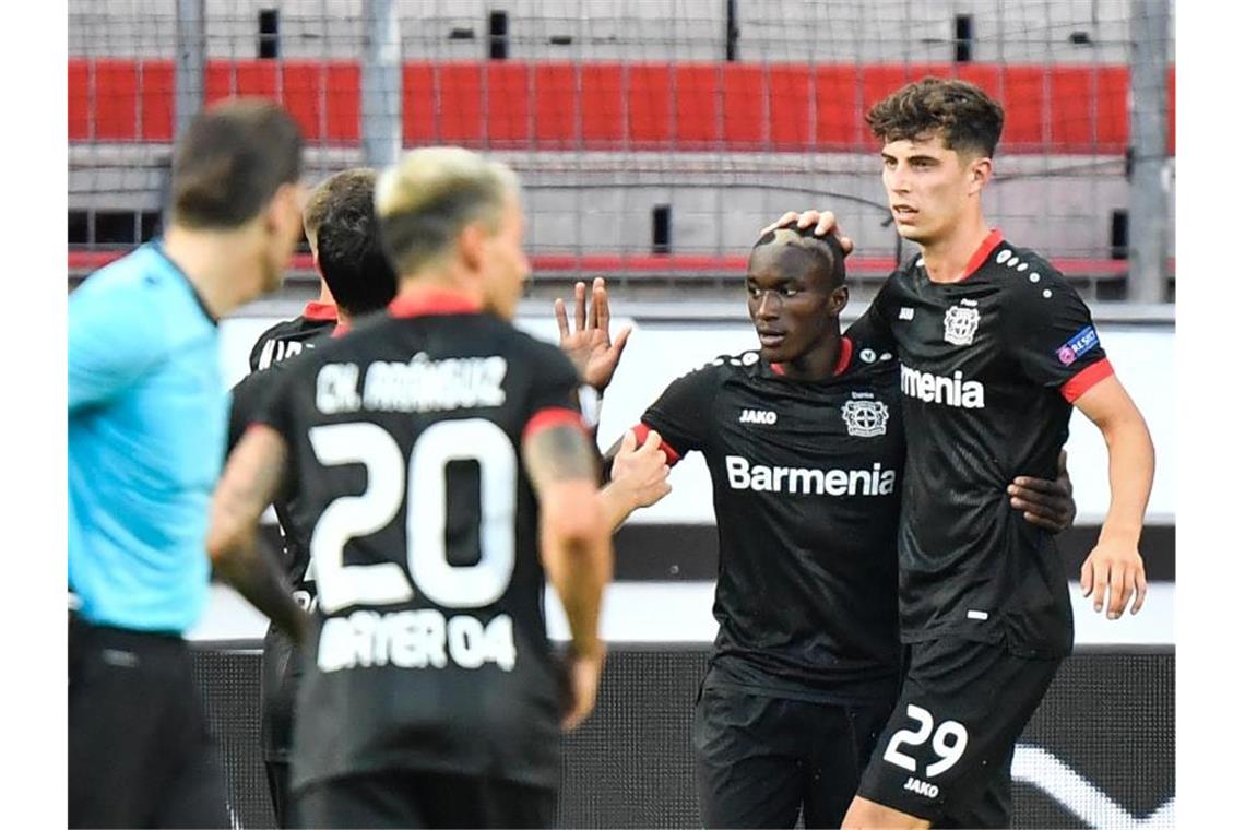 Leverkusens Torschütze Moussa Diaby (2.v.r.) feiert seinen Treffer zum 1:0 gegen die Glasgow Rangers mit mit Kai Havertz. Foto: Martin Meissner/AP-Pool/dpa