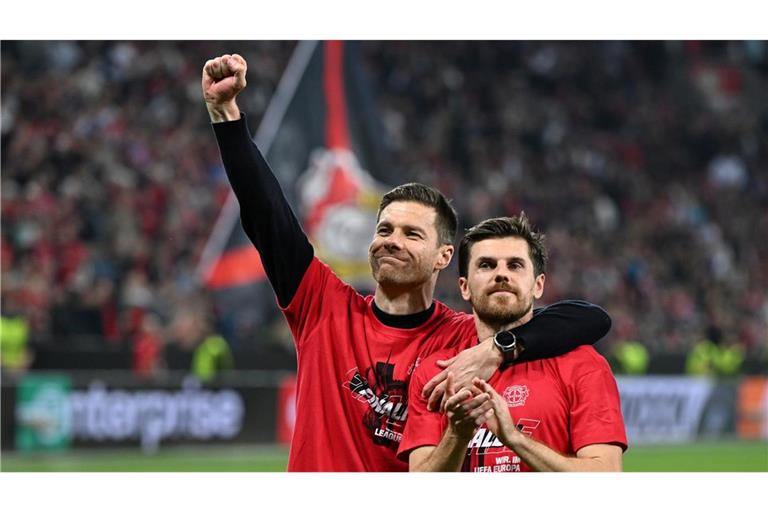 Leverkusens Trainer Xabi Alonso und Jonas Hofmann (r) feiern mit den Fans nach dem Spiel gegen Rom.