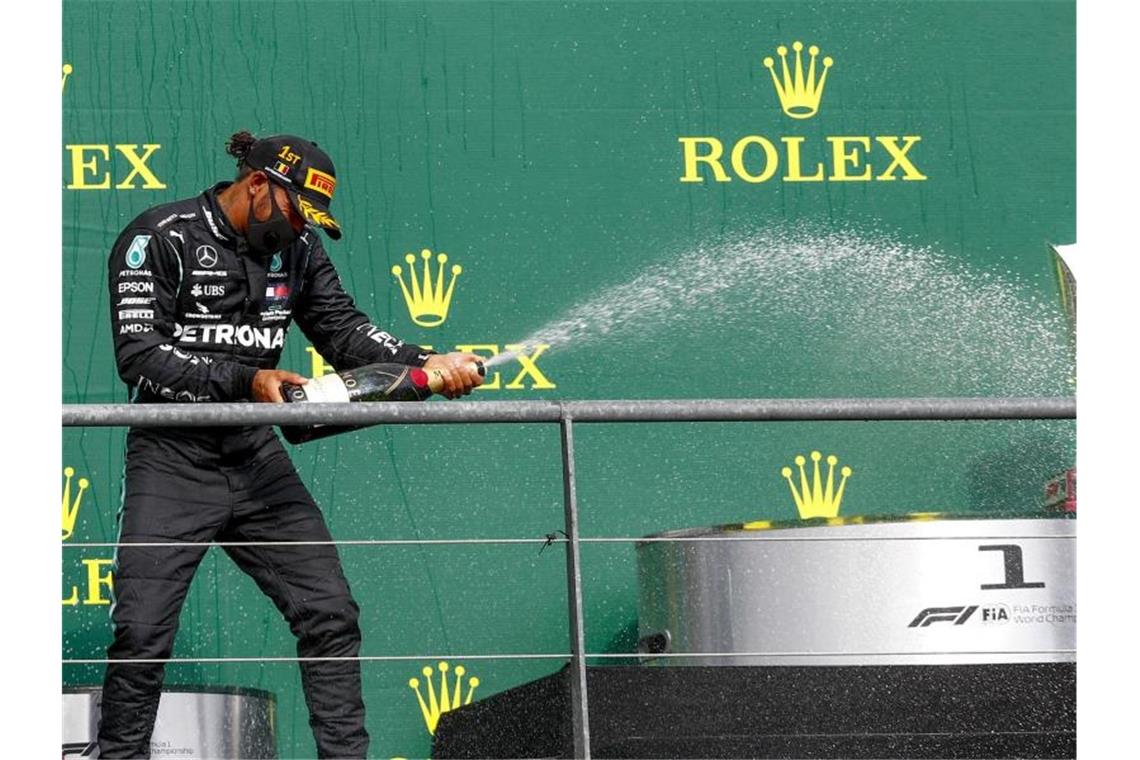 Lewis Hamilton feiert seinen Sieg mit der obligatorischen Champagner-Dusche. Foto: Francois Lenoir/POOL REUTERS/AP/dpa