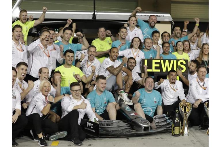 Lewis Hamilton (M) und Team Mercedes jubeln nach der erfolgreichen Saison, die mit dem sechsten WM-Titel für Hamilton zu Ende ging. Foto: Hassan Ammar/AP/dpa