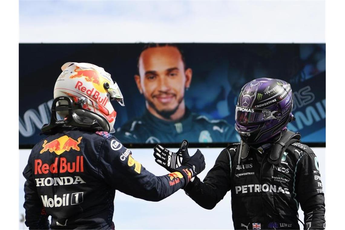 Lewis Hamilton (r) und Max Verstappen liefern sich einen Zweikampf an der Spitze. Foto: Gabriel Bouys/Pool AFP/AP/dpa