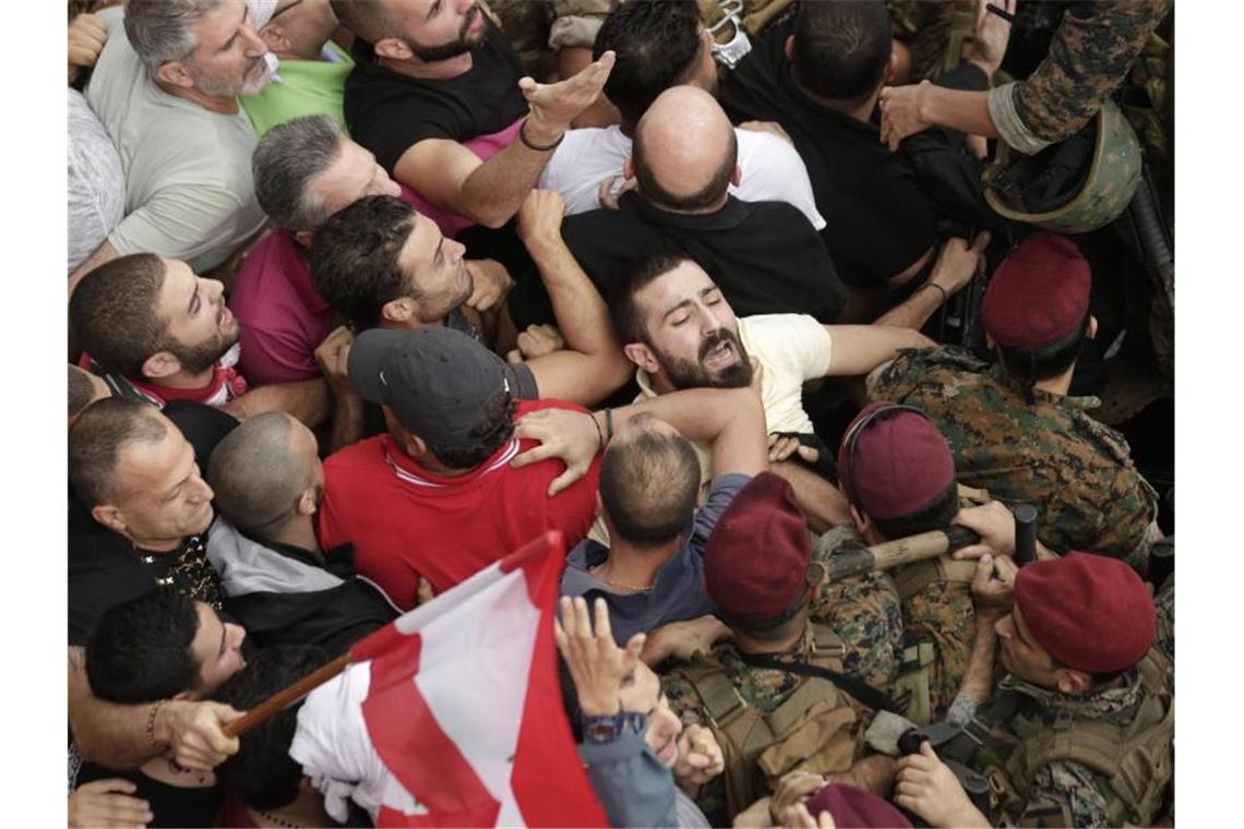 Libanesische Soldaten versuchen Demonstranten während eines Protests zurückzutreiben. Foto: Hassan Ammar/AP/dpa