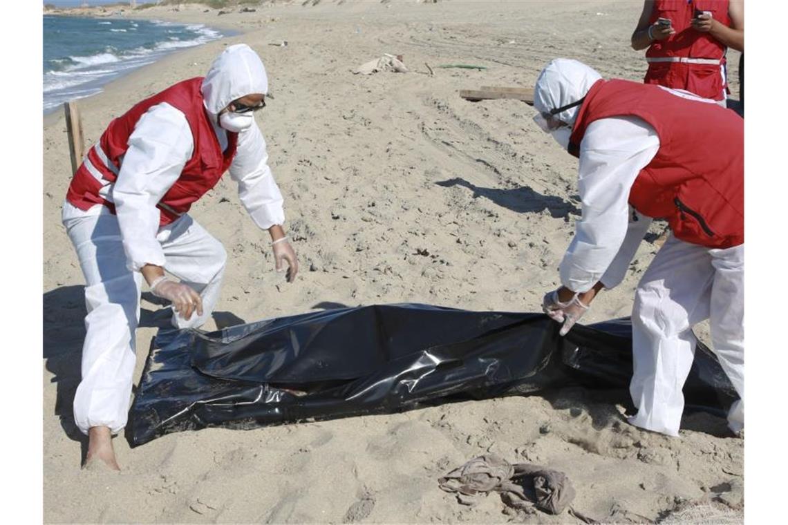 Hilfsorganisation befürchtet bis zu 200 Tote vor Libyen Libysche Mitarbeiter des Roten Halbmonds bergen die Leiche eines ertrunkenen Migranten. Foto: Hazem Ahmed/AP