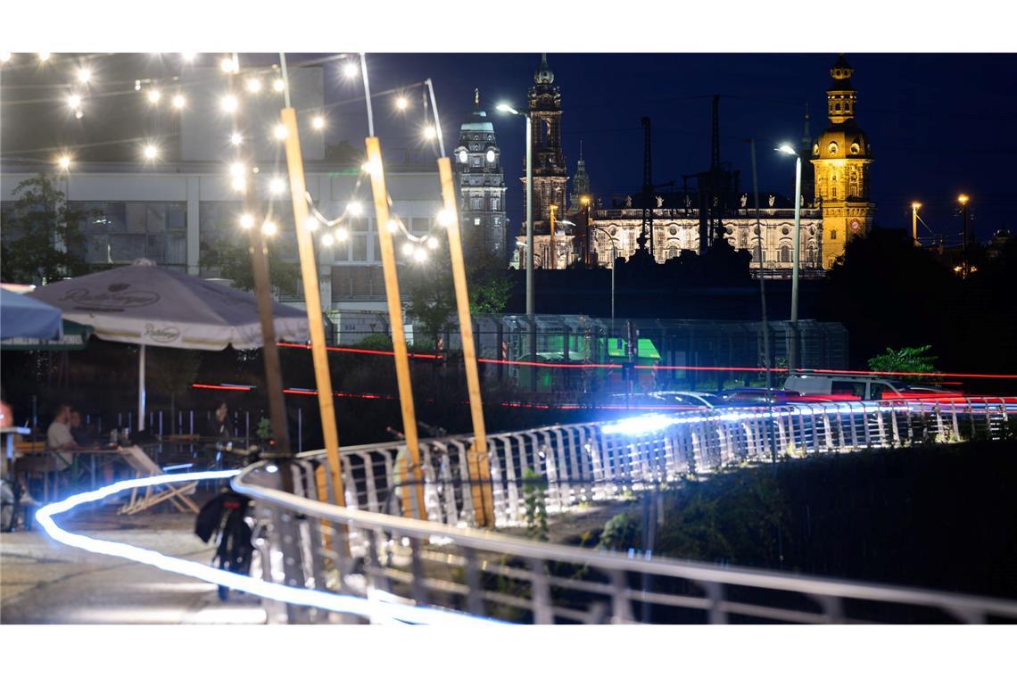 Lichter eines Restaurants am Neustädter Hafen im neuen Wohnviertel Hafencity leuchten am Abend an der Uferpromenade in Dresden.