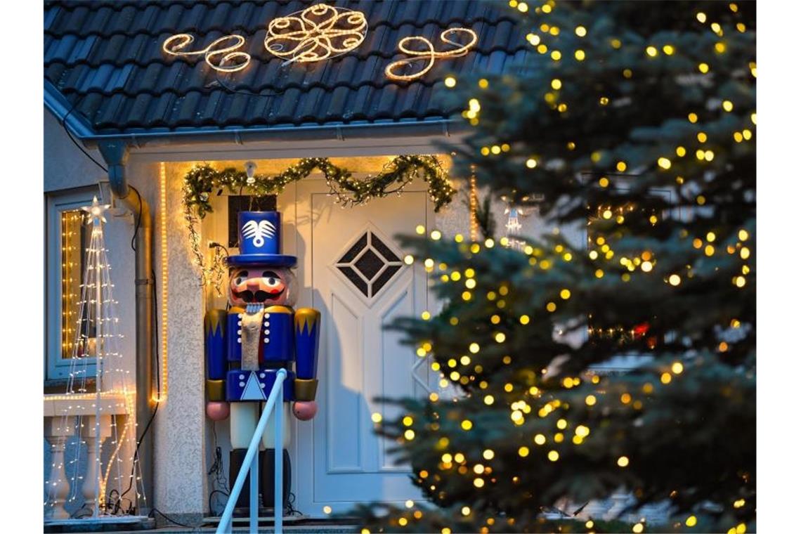 Stromverbrauch steigt nach Feiertagsdelle wieder Lichterketten und ein großer Nussknacker stehen an einem weihnachtlich geschmückten Hauseingang. Foto: Patrick Pleul/zb/dpa