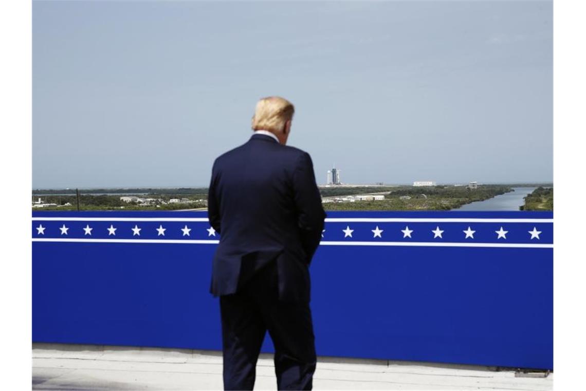 Raumfahrer wieder von den USA aus zur ISS gestartet Lies sich den Start nicht entgehen: US-Präsident Donald Trump verfolgt auf einer Aussichtsplattform, wie die SpaceX „Falcon 9“-Rakete sich auf den Start vorbereitet. Foto: Alex Brandon/AP/dpa