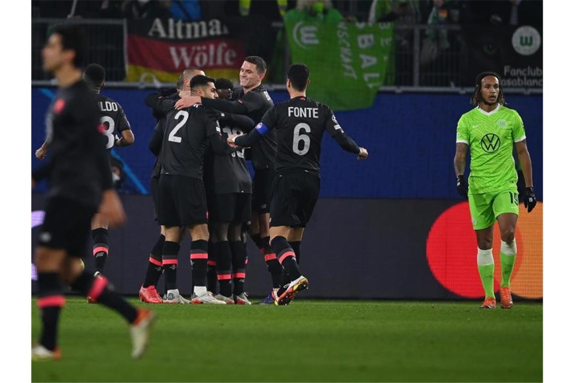 Lilles Spieler (l) jubeln nach dem frühen Tor durch Burak Yilmaz zur 1:0-Führung beim VfL Wolfsburg. Foto: Swen Pförtner/dpa
