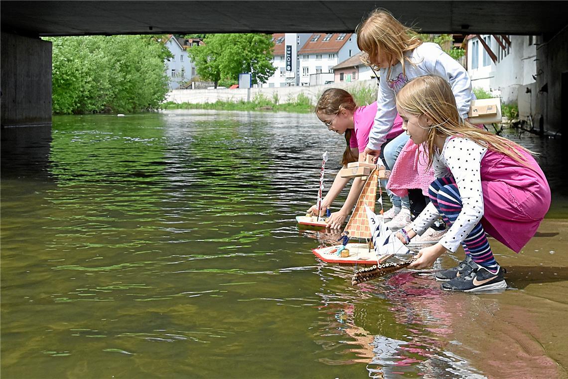 Lilli (rechts) lässt ihr Boot und das ihres Bruders Johann zu Wasser. Auch die große Schwester Emma (links) schickt ihr Modell nach dem Startsignal bei der Mini-Murr-Regatta an der Murrtreppe ins Rennen. Fotos: Tobias Sellmaier