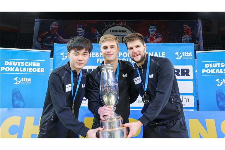 Lin Yun-ju (l-r), Truls Moregardh und Dimitrij Ovtcharov, alle von TTC Neu-Ulm, jubeln mit dem Champions-League-Pokal. In der Bundesliga spielt der Verein nicht mehr mit.