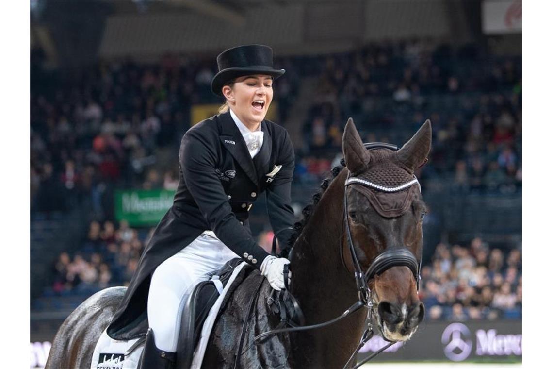 Dressur: Lisa Müller siegt überraschend, Thomas feiert mit Lisa Müller feiert ihren ersten Platz auf ihrem Pferd Stand by me. Foto: Sebastian Gollnow/dpa