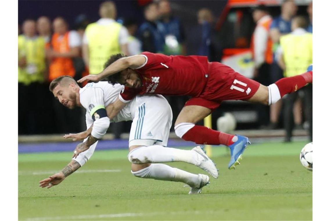 Liverpool-Stürmer Mohamed Salah musste im Finale 2018 nach diesem Zweikampf mit Real-Kapitän Sergio Ramos verletzt vom Platz. Foto: Efrem Lukatsky/AP/dpa