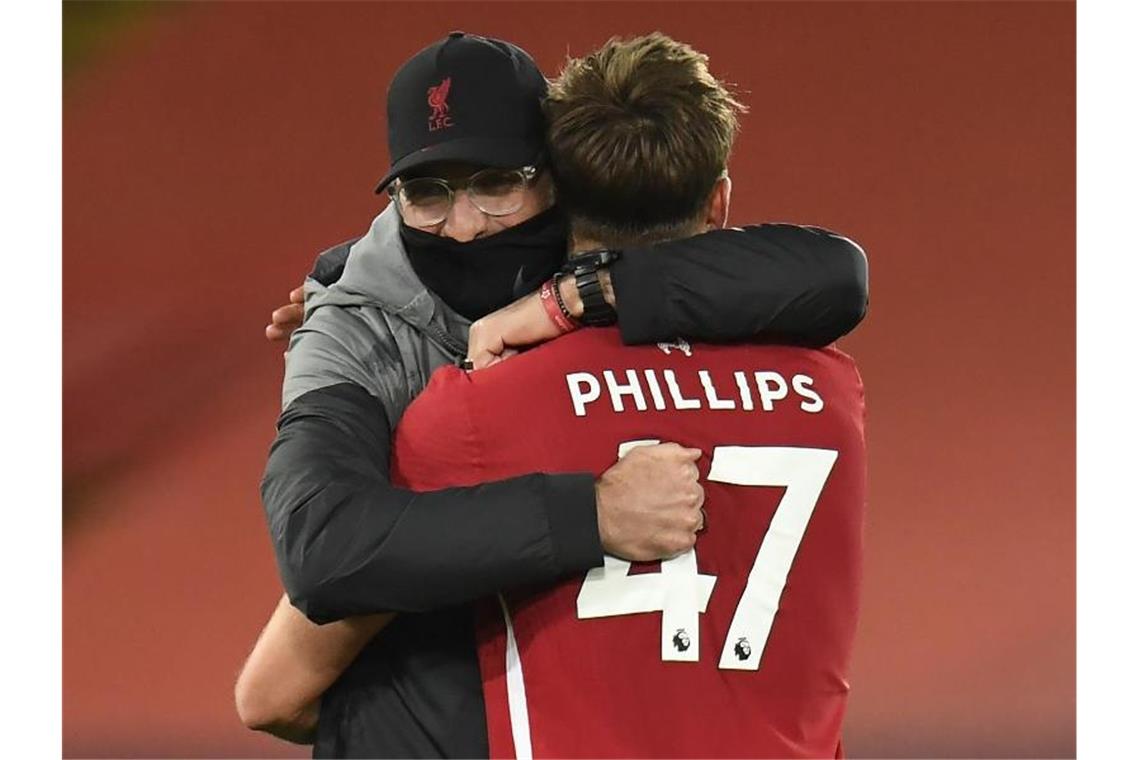 Liverpools Coach Jürgen Klopp umarmt nach dem Spiel Nathaniel Phillips. Foto: Peter Powell/PA Wire/dpa