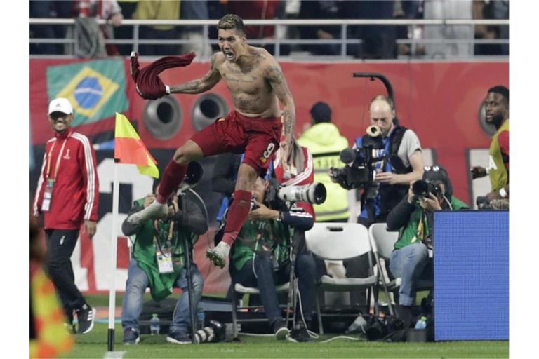 Liverpools Roberto Firmino (M) feiert den ersten Treffer seiner Mannschaft. Foto: Hassan Ammar/AP/dpa