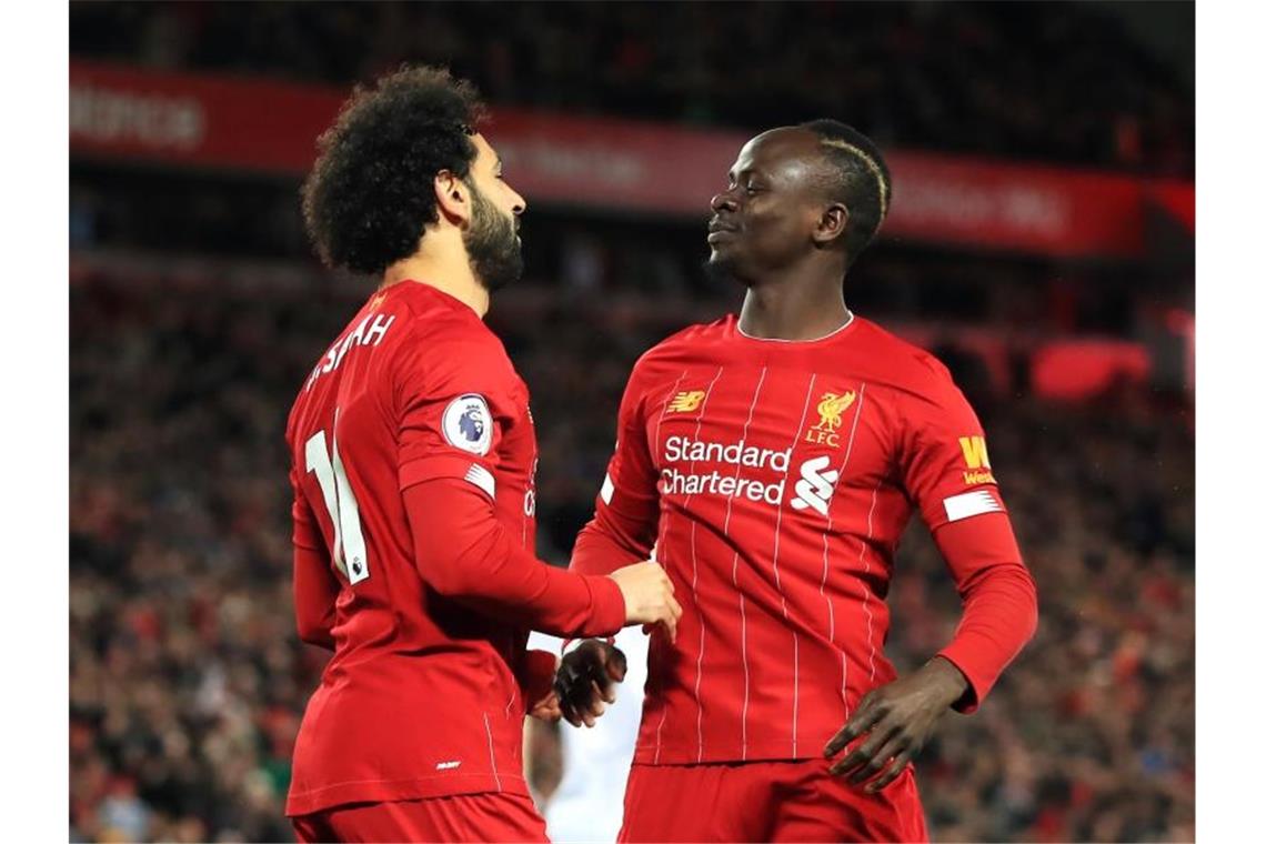 Liverpool ein Jahr unbesiegt - Klopp: Bettruhe statt Party Liverpools Torschütze Mohamed Salah (l) jubelt über das 1:0 mit seinem Teamkollegen Sadio Mane. Foto: Peter Byrne/PA Wire/dpa
