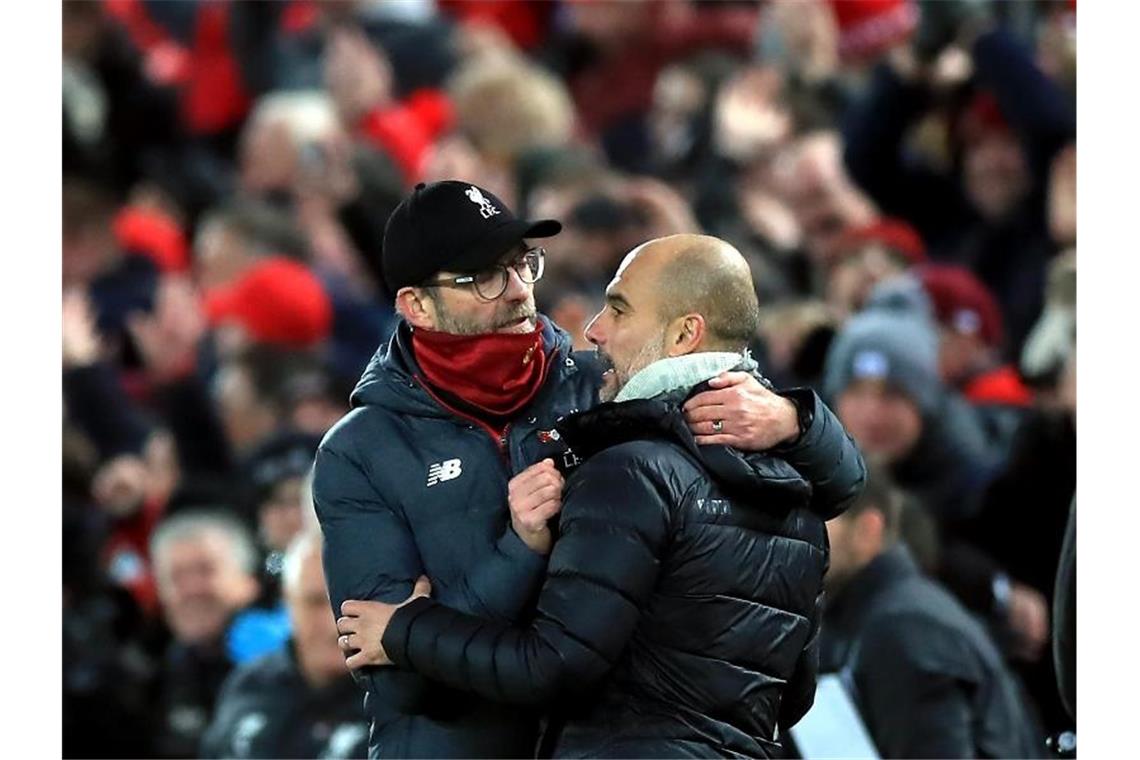 Liverpools Trainer Jürgen Klopp (l) und Man-City-Coach Pep Guardiola umarmen sich nach dem Abpfiff. Foto: Peter Byrne/PA Wire/dpa