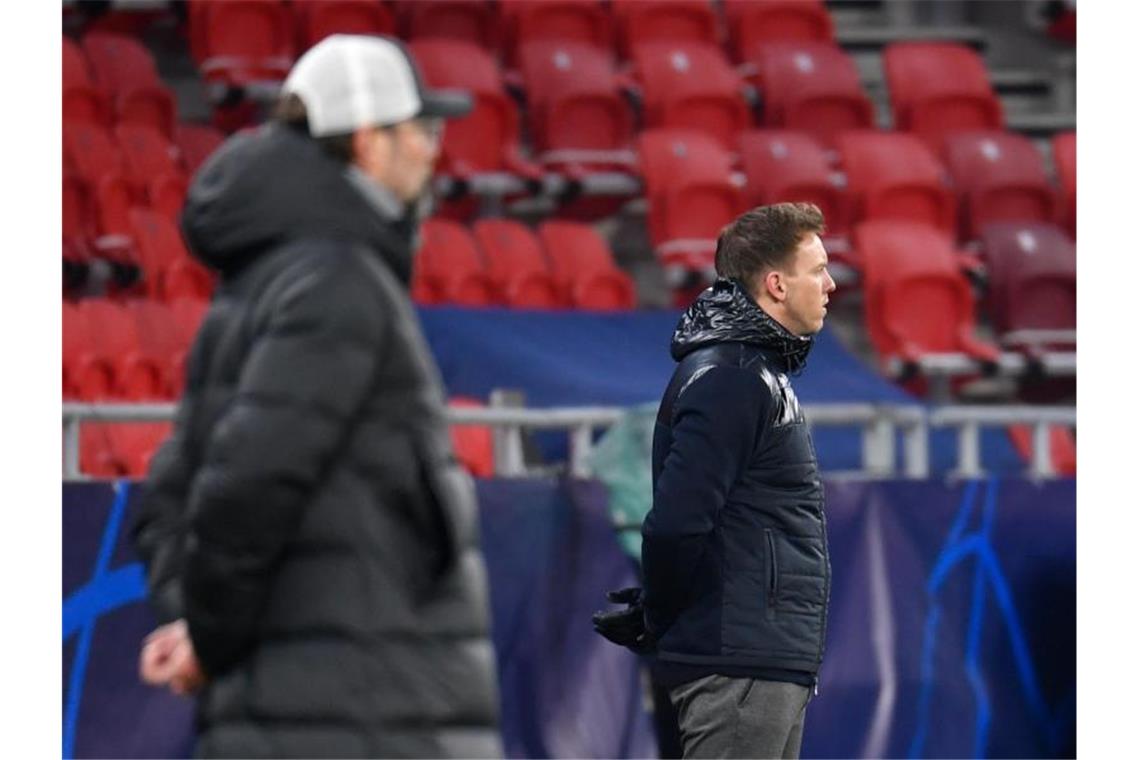 Liverpools Trainer Jürgen Klopp und Leipzigs Trainer Julian Nagelsmann (r) stehen am Spielfeldrand. Foto: Marton Monus/dpa