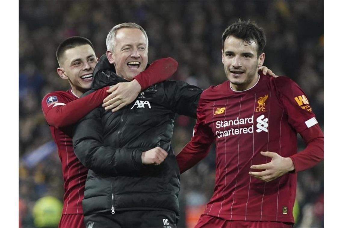 Liverpools U23-Coach Neil Critchley (M) jubelt mit Adam Lewis (l) und Pedro Chirivella (r) über den Einzug ins Achtelfinale. Foto: Jon Super/AP/dpa