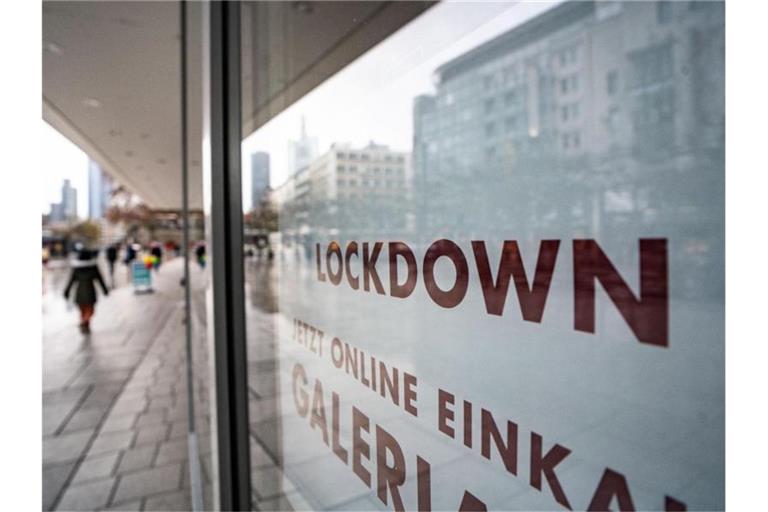 „Lockdown“ steht im Schaufenster eines geschlossenen Kaufhauses, das darunter zum Online-Einkauf rät. Foto: Frank Rumpenhorst/dpa
