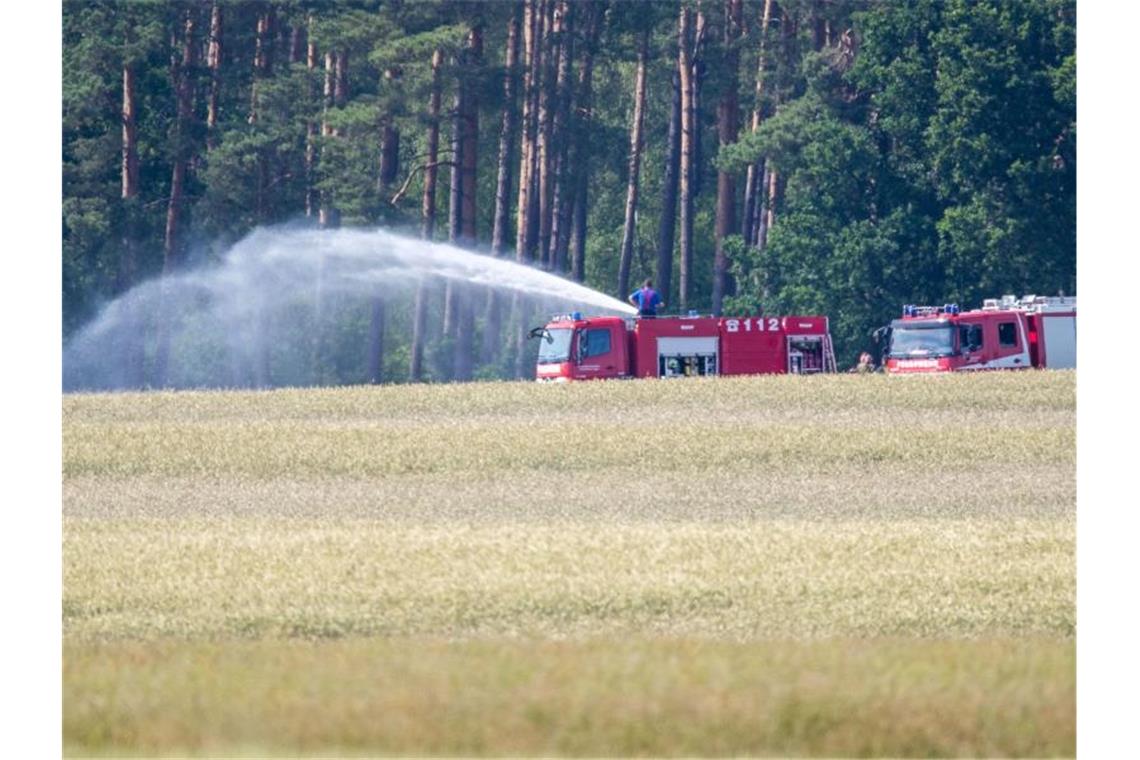 Löscharbeiten an einer der Absturzstellen in einem Feld in der Nähe von Nossentiner Hütte. Foto: Jens Büttner