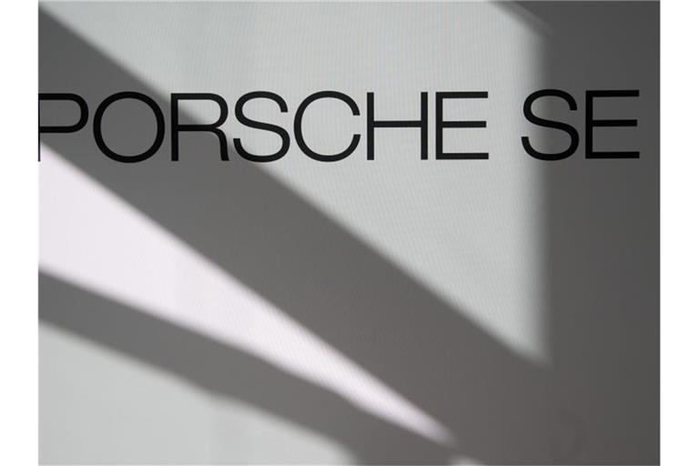 Logo und Schriftzug der Porsche SE sind an einer Stellwand zu sehen. Foto: Marijan Murat/dpa/Symbolbild