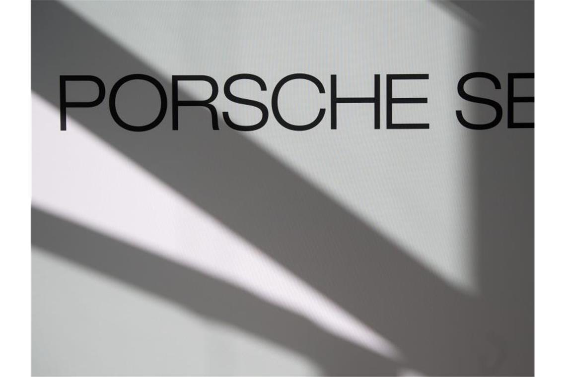 Logo und Schriftzug der Porsche SE sind an einer Stellwand zu sehen. Foto: Marijan Murat/Archiv