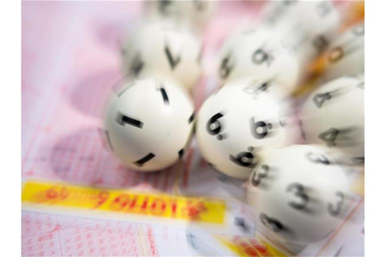 Lotto-Kugeln liegen auf einem Lottoschein. Foto: Tom Weller/dpa/Symbolbild