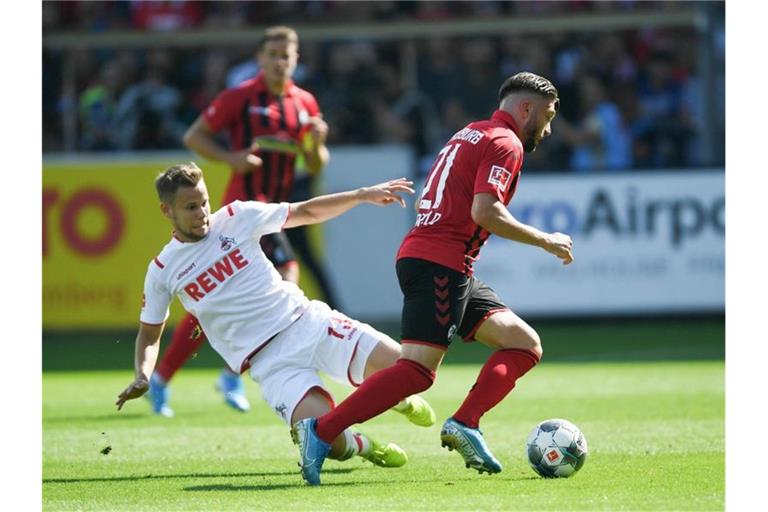 Louis Schaub (l) von Köln und Brandon Borrello von Freiburg kämpfen um den Ball. Foto: Patrick Seeger/dpa/Archivbild
