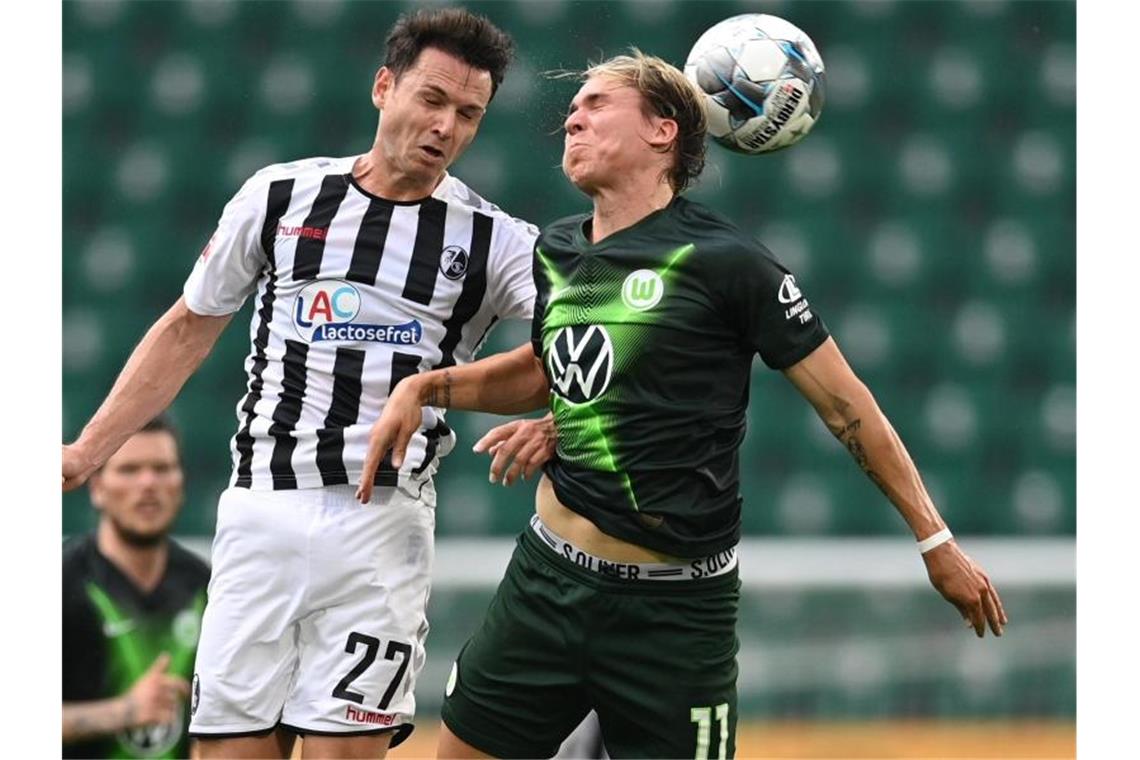 Lucas Höler (l) konnte mit dem SC Freiburg einen Punkt in Wolfsburg ergattern. Foto: Sascha Steinbach/epa Pool/dpa