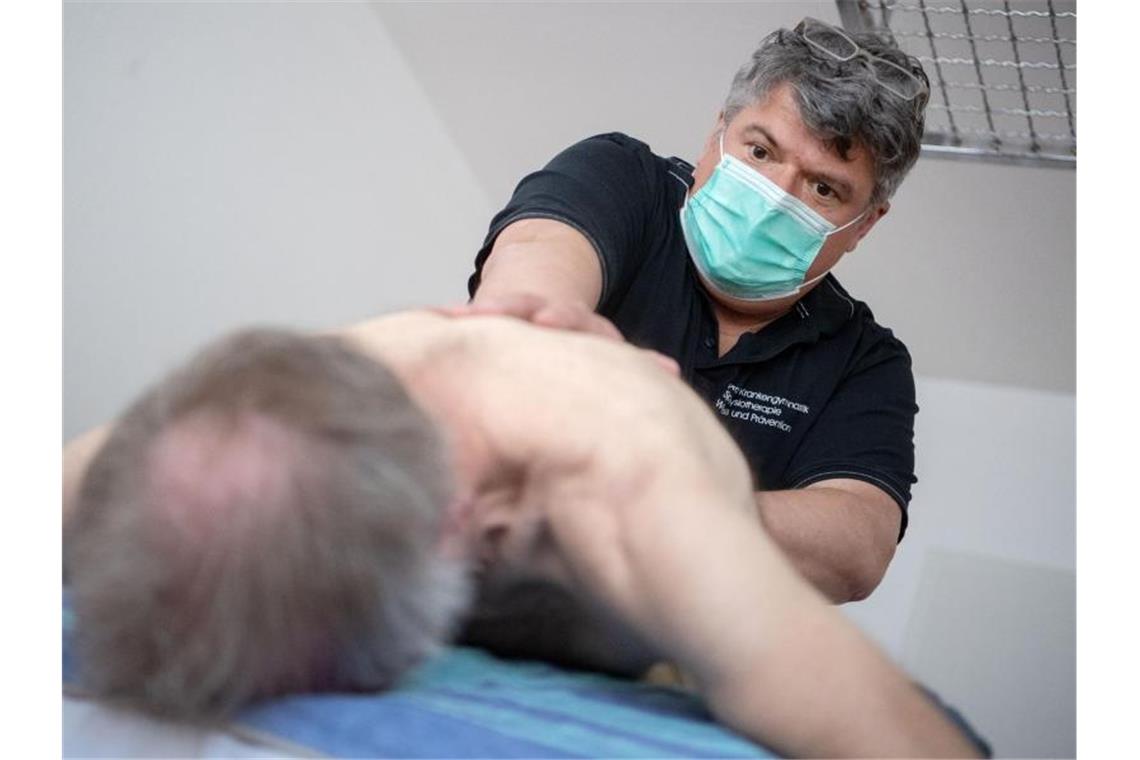 Anfassen erwünscht: Physiotherapie in Zeiten von Corona Lucian Kokott behandelt in seiner Praxis einen Patienten. Foto: Marijan Murat/dpa