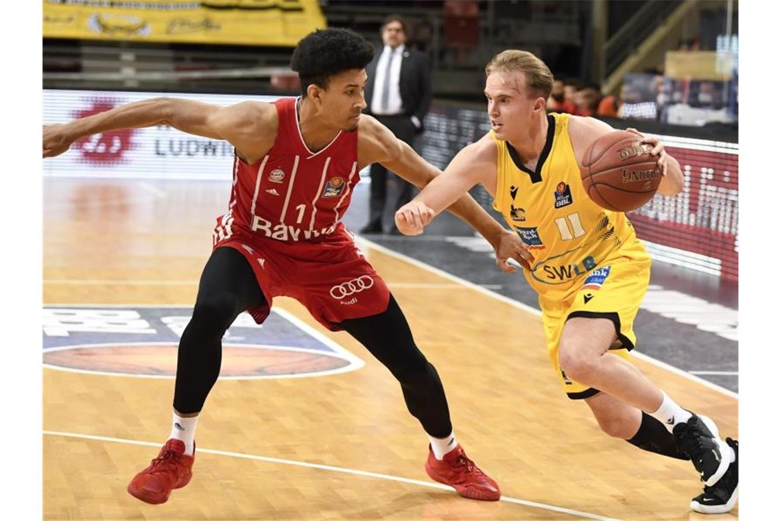 Ludwigsburgs Basketballer verlängern mit Youngster Herzog Ludwigsburgs Lukas Herzog (r) im Zweikampf mit Münchens Jason George . Foto: Thomas Kienzle/dpa/Archivbild