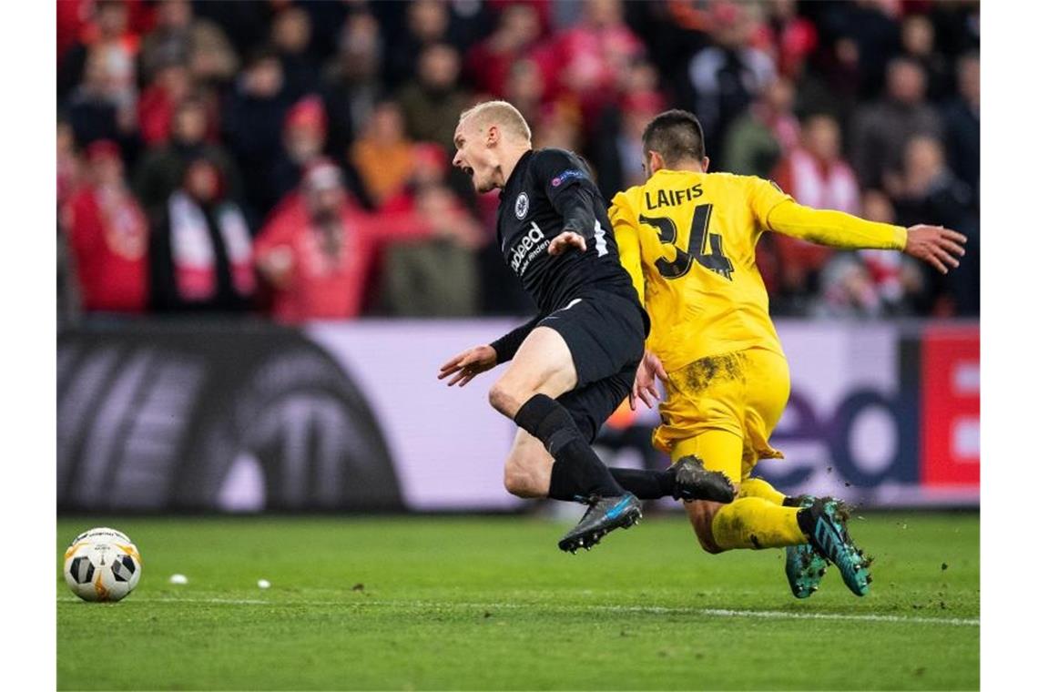 Lüttichs Kostas Laifis (r) foult Eintracht-Spieler Sebastian Rode. Foto: Marius Becker/dpa