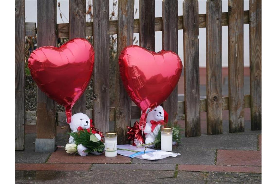 Luftballons, Plüschtiere und Kerzen liegen vor dem Haus in Glinde. Foto: Marcus Brandt/dpa