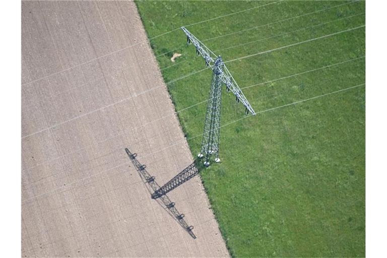 Luftbild, aus einem Flugzeug aufgenommen, von einem Freileitungsmasten auf einem Feld. Foto: Uli Deck/dpa/Archivbild