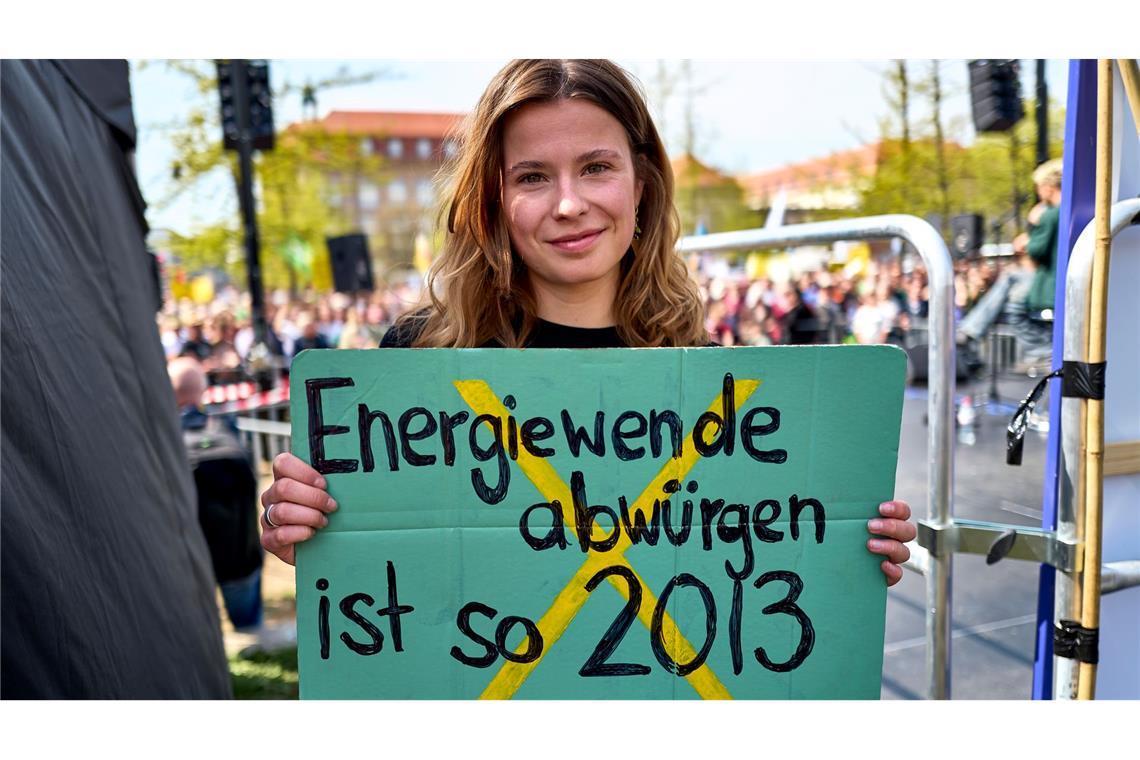 Luisa Neubauer hält ein Schild mit der Aufschrift "Energiewende abwürgen ist so 2013" in der Hand.