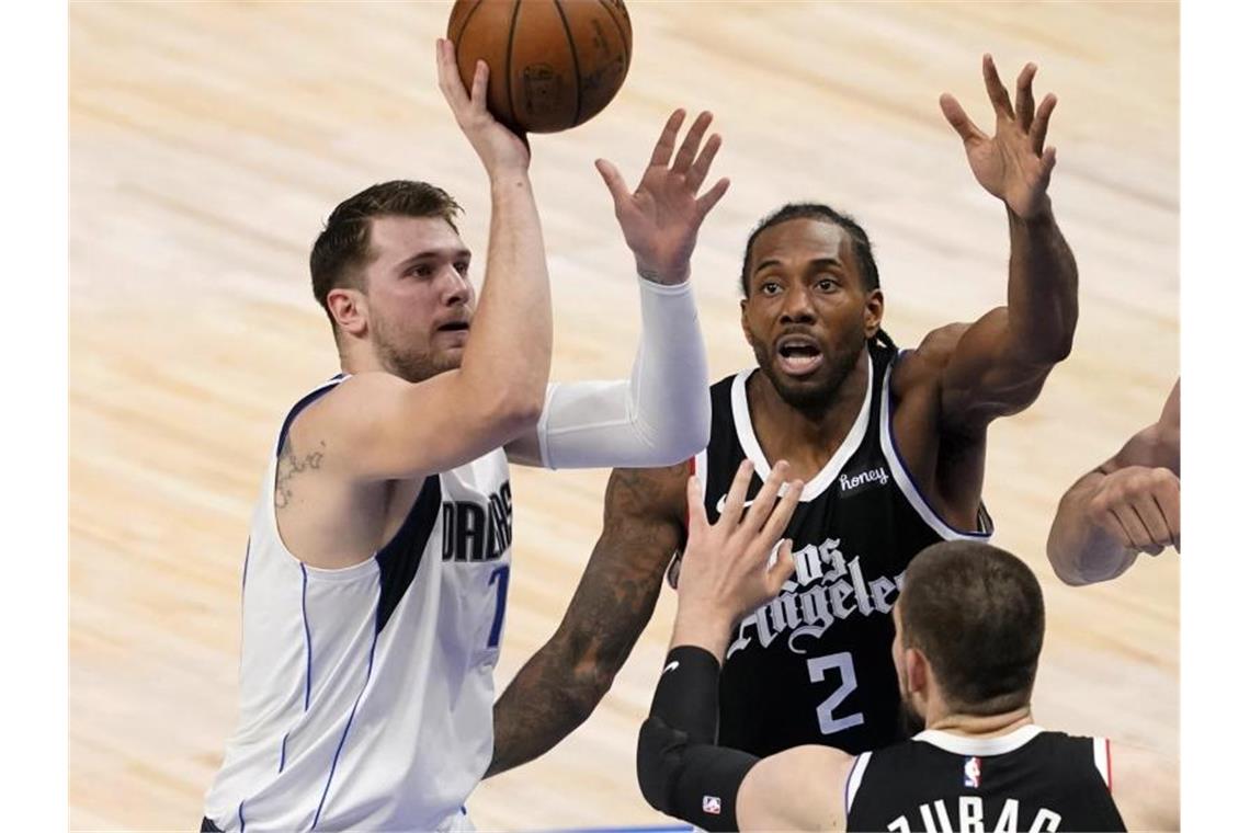 Rückschläge in den Playoffs für Schröder und Kleber Luka Doncic (l) von den Dallas Mavericks wirft, während Kawhi Leonard (2) und Ivica Zubac von den Los Angeles Clippers verteidigen. Foto: Tony Gutierrez/AP/dpa