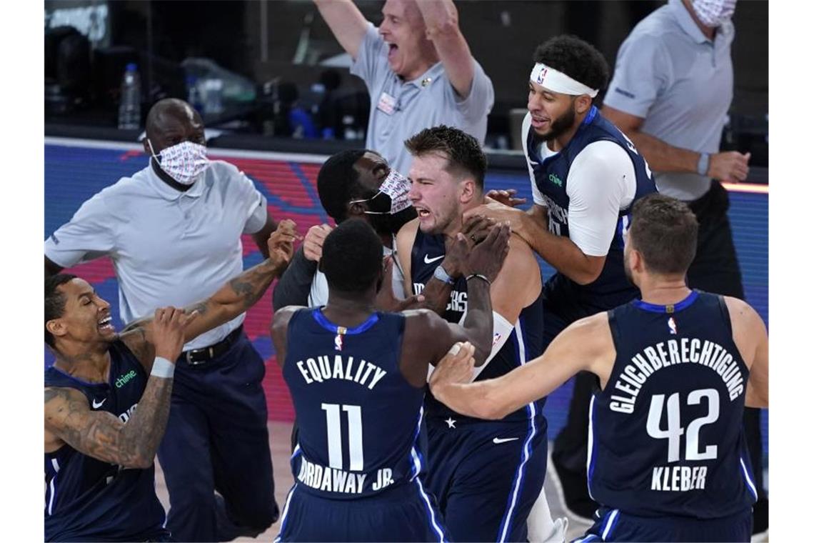 Luka Doncic (M) von den Dallas Mavericks feiert mit seinen Teamkollegen. Foto: Ashley Landis/Pool AP/dpa