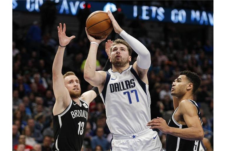 Luka Doncic (M/77) von den Mavs kommt zu einem Wurf gegen Dzanan Musa (13) und Timothe Luwawu-Cabarrot (9) von den Brooklyn Nets. Foto: Brandon Wade/FR168019 AP/dpa