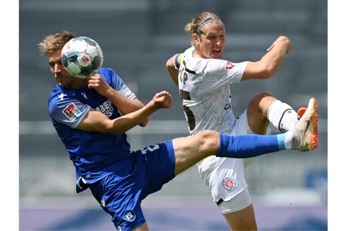 Lukas Grozurek (l.) vom Karlsruher SC und Henk Veerman vom FC St. Pauli kämfen um den Ball. Foto: Matthias Hangst/Getty Images Europe/Pool/dpa