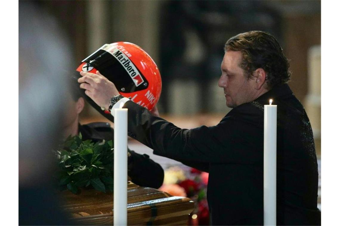 Lukas Lauda legt den Helm seines Vaters Niki auf den Sarg. Foto: Georg Hochmuth/APA