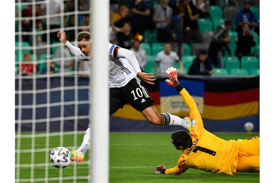 Lukas Nmecha (Deutschland, l) erzielt gegen Portugals Torhüter Diogo Costa das Tor zur 1:0-Führung. Foto: Marton Monus/dpa
