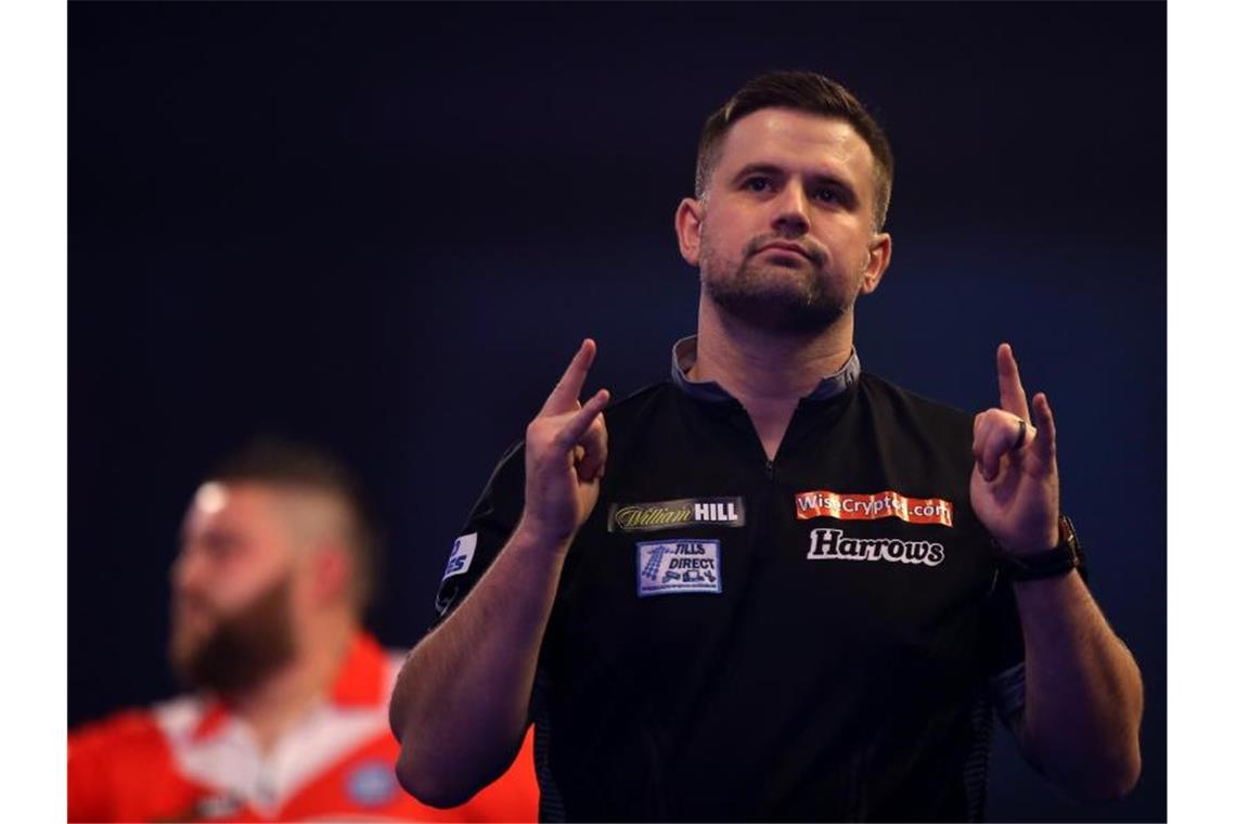 Erster Frauen-Sieg bei Darts-WM bleibt aus Luke Woodhouse (r) feiert seinen Sieg über Michael Smith (hinten). Foto: Steven Paston/PA Wire/dpa