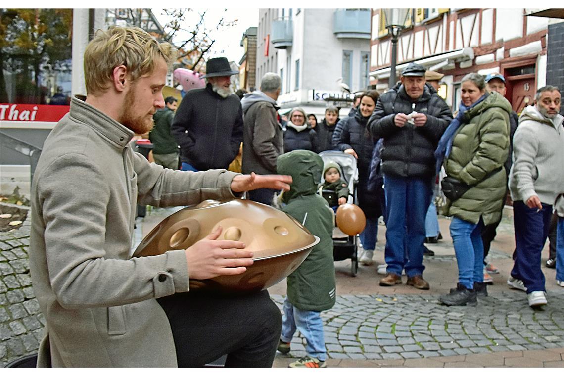 Lusimeon spielt auf der Handpan und erklärt interessierten Besuchern das ausserg...