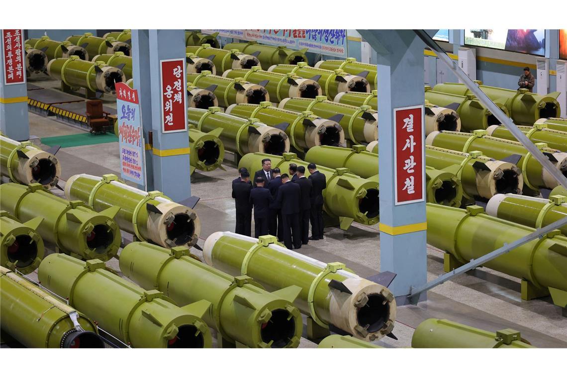 Machthaber Kim Jong Un (M) inspiziert Raketenproduktion.