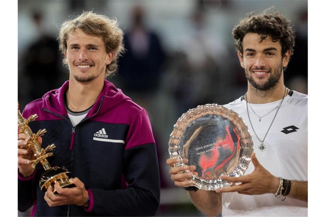 Madrid-Sieger Alexander Zverev (l) und der Zweitplatzierte Matteo Berrettini erhalten ihre Trophäen während der Siegerehrung. Foto: Bernat Armangue/AP/dpa