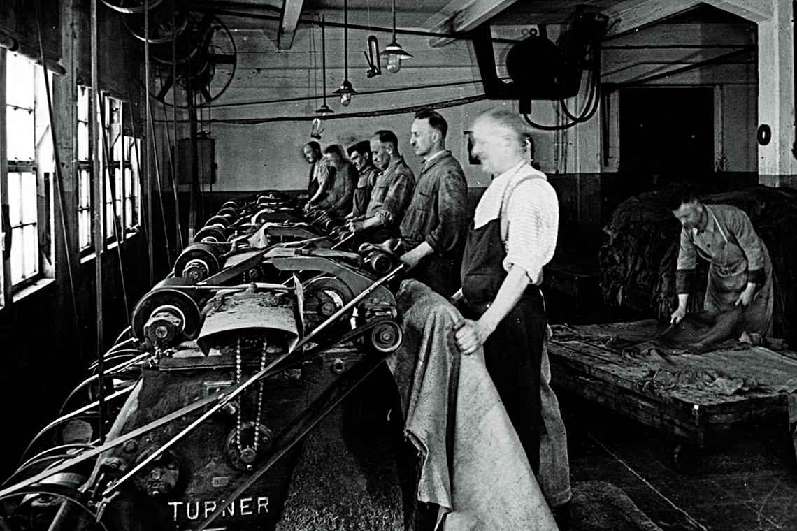 Männer arbeiten 1938 an den Falzmaschinen in der Lederfabrik von Fritz Häuser. Bereits zehn Jahre zuvor erreichte die Fritz Häuser AG mit 708 Mitarbeitern ihre höchste Beschäftigtenzahl.